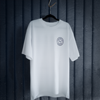Cut 001 white t-shirt front displayed on hanger showing natural drape and heavyweight fabric construction - against a white wall.